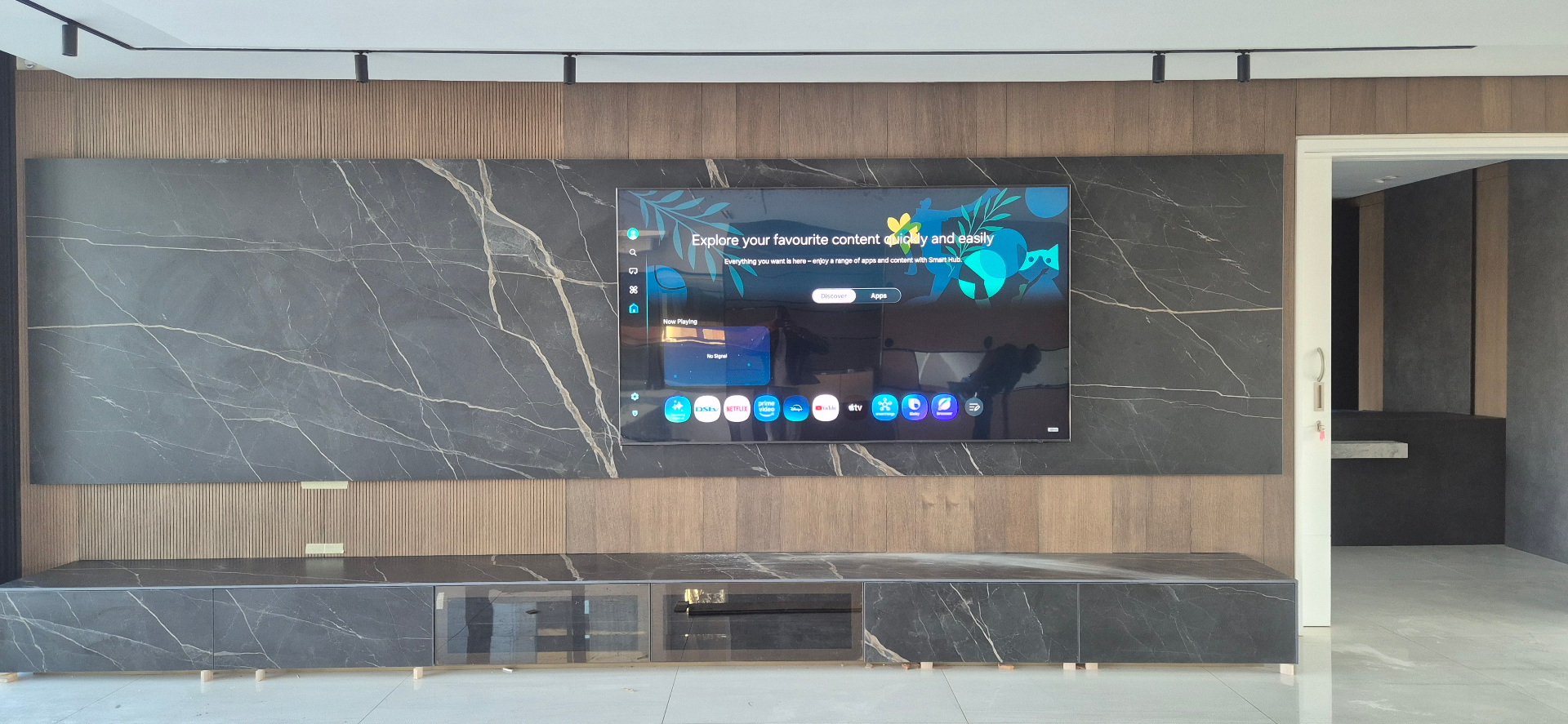 Flush-mounted big screen TV on marble and timber media wall in a Gauteng home