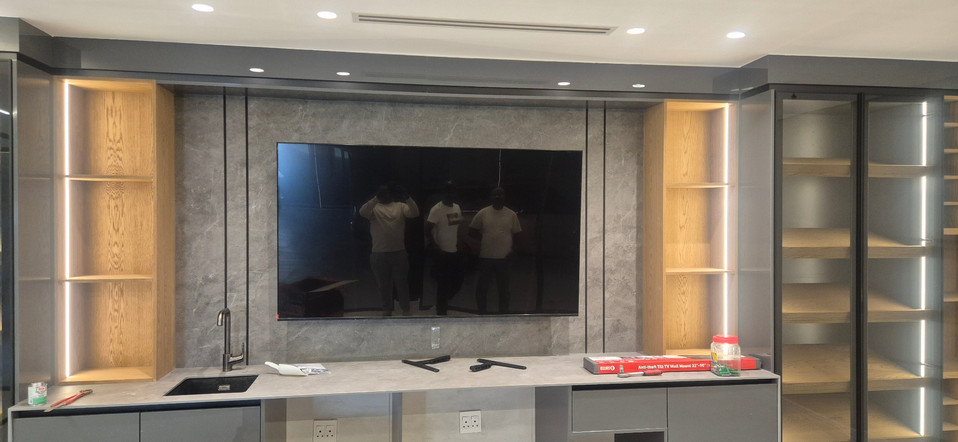 Anti-theft tilt bracket TV installation in a modern entertainment cabinet