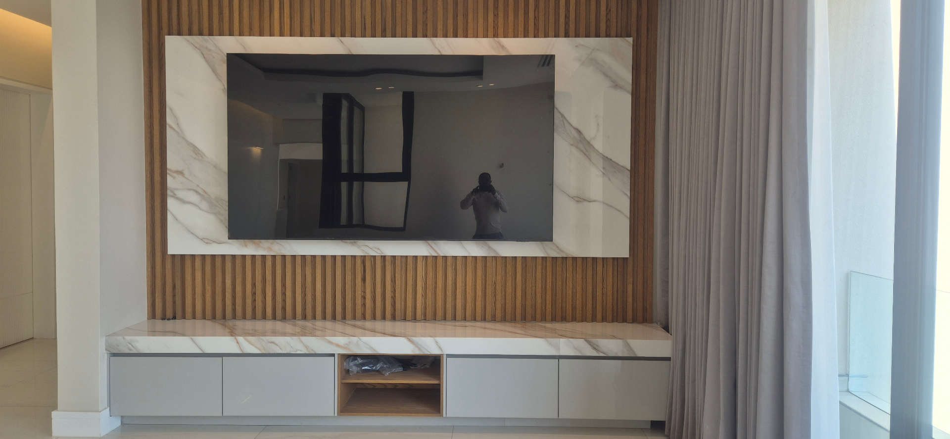 Level TV installation on a marble and timber wall with no visible cables