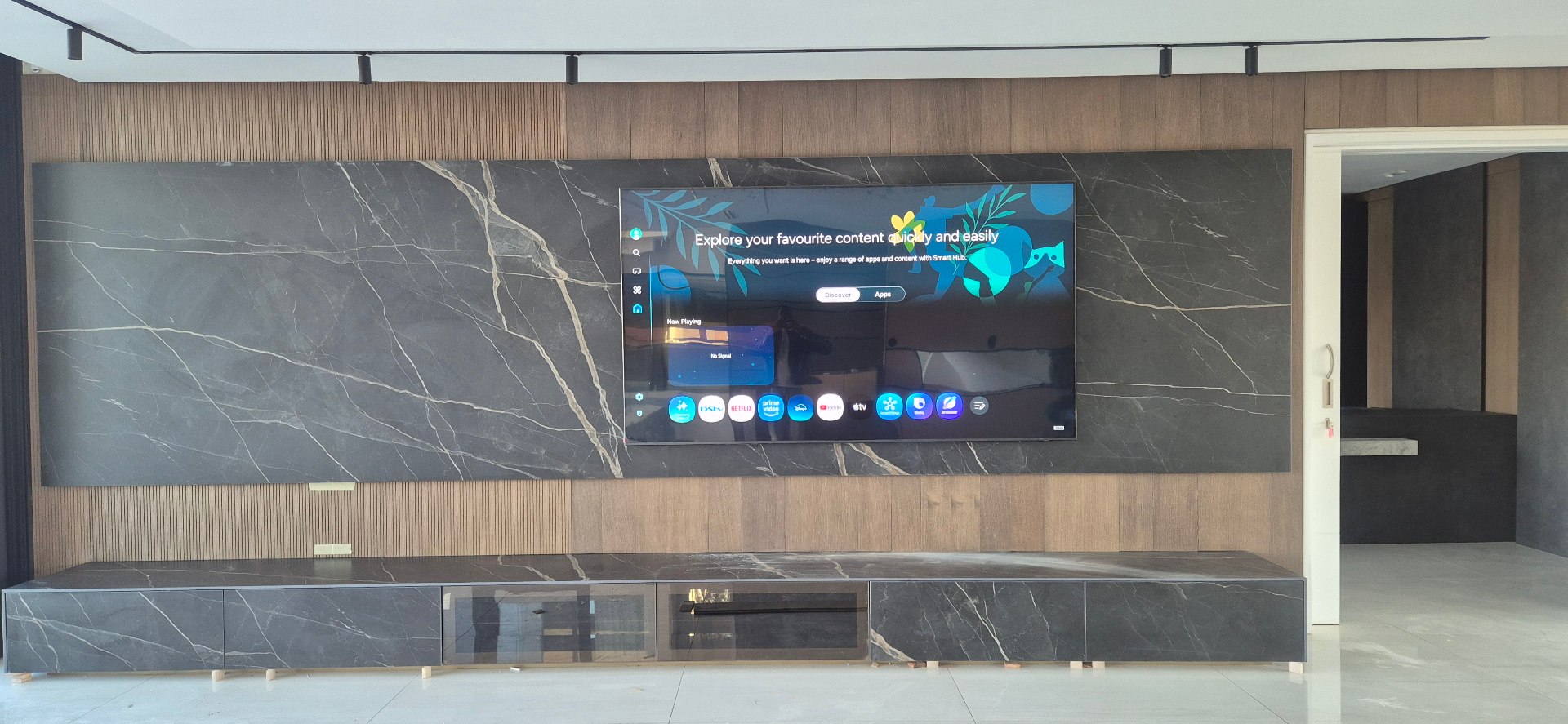 Wall mounted smart TV centred on a stone panel above a floating media unit